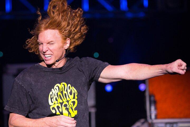 a man with red hair and a microphone - reviews carrot top shows las vegas